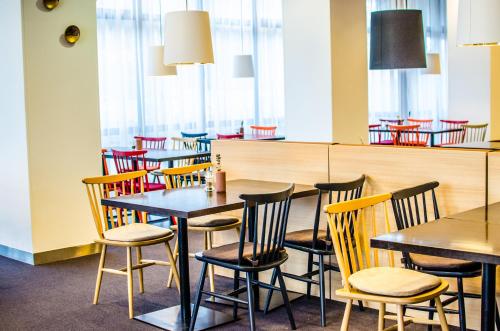 a row of tables and chairs in a restaurant at Vienna House Easy by Wyndham Bucharest Airport in Otopeni