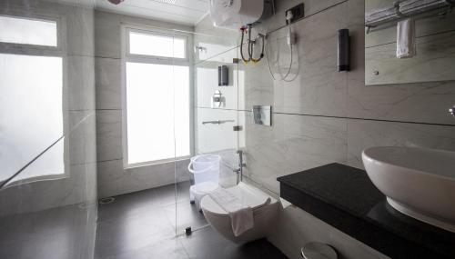 La salle de bains blanche est pourvue d'un lavabo et de toilettes. dans l'établissement Mount Lungta Boutique Hotel & Spa, à Darjeeling