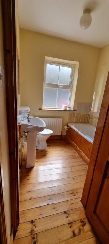 a bathroom with a tub and a sink and a bath tub at Moulamill Cottage in Gouladane