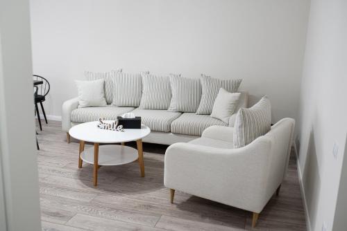 a living room with a couch and a table and chairs at TEILOR Apartments 3 in Floreşti