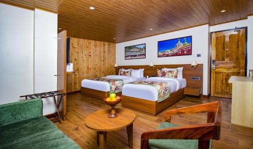Habitación de hotel con 2 camas y sofá en Mount Lungta Boutique Hotel & Spa, en Darjeeling