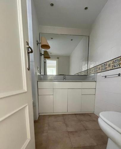 a bathroom with a mirror and a sink and a toilet at FRENTE AL MAR in Burriana