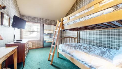 sypialnia z 2 łóżkami piętrowymi, biurkiem i telewizorem w obiekcie Sierra Megeve #8 Condo w mieście Mammoth Lakes