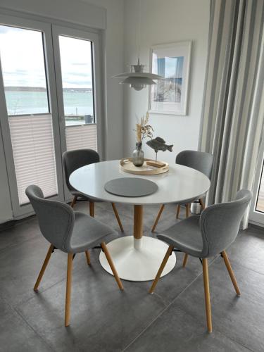 a dining room with a white table and chairs at Ferienhaus SEE & Ferienhaus SEEBLICK in Neukieritzsch