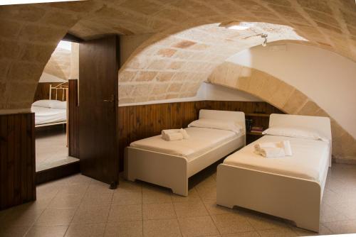 two beds in a room with a brick wall at La Casa dell'oste in Monopoli