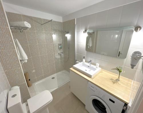 Un baño con inodoro, lavabo y ducha. en Casa Nature, en Playa de Santiago