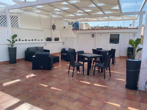 een restaurant met zwarte tafels en stoelen op een patio bij Maison Brancaleone in Barletta