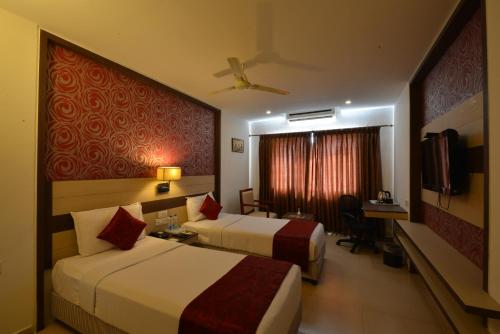a hotel room with two beds and a desk at SRM Hotel in Tuticorin