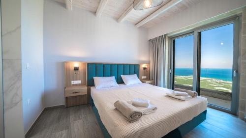 a bedroom with a large bed with towels on it at Nafsika Xenia - Alkinoos Villa in Plátanos