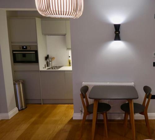 uma cozinha com uma mesa e duas cadeiras e um balcão em Stylish Studio Apartment, ensuite, kitchenette em Twickenham