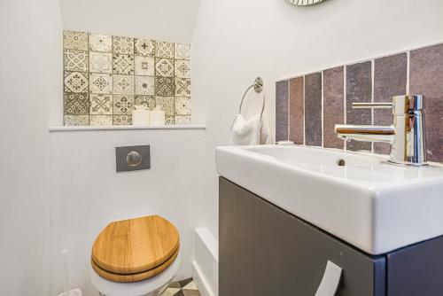 W łazience znajduje się biała umywalka i drewniana toaleta. w obiekcie Corner Lodge Bishophill York - FREE PARKING w mieście York