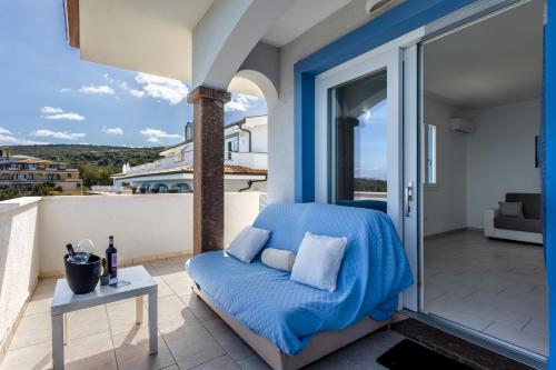 a balcony with a blue bed and a table at Appartamenti Rocca 'Ja in Castelsardo