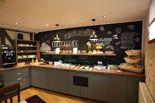 a restaurant with a counter with food on it at Pension Alte Scheune in Melsungen