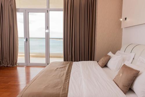 a bedroom with a bed with a view of the ocean at Deluxe & Executive SPA by Rafaelo in Shëngjin