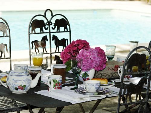 a table with a tea set with flowers on it at Château de l'Isle - Chambres d'Hôtes in Castelnau-de-Médoc