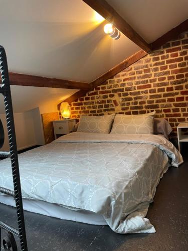 a bedroom with a bed in a brick wall at L entrepote in Dieppe