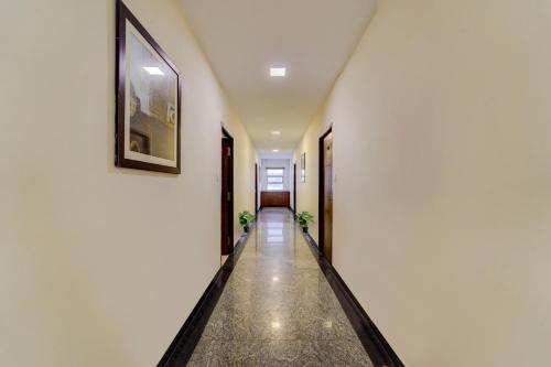 un pasillo con paredes blancas y una foto en la pared en OYO Townhouse 1116 US consulate, en Chennai