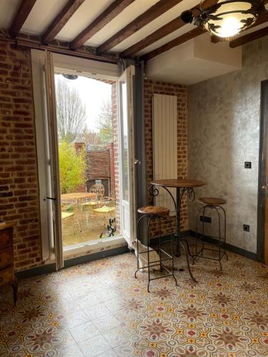 a room with a patio with a table and chairs at L entrepote in Dieppe