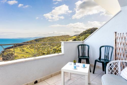 a room with a balcony with two chairs and a table at Appartamenti Rocca 'Ja in Castelsardo