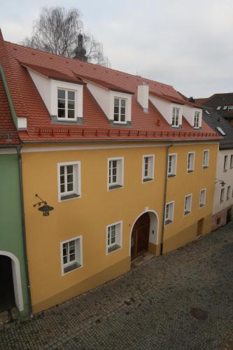 a yellow building with a red roof at Roomerie im Zentrum in Sulzbach-Rosenberg