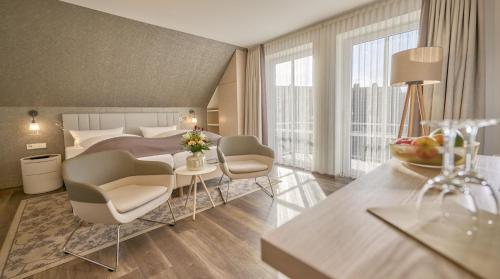 Habitación de hotel con cama, mesa y sillas en Janssens Hotel en Neuharlingersiel