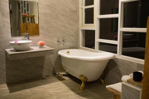 a bathroom with a bath tub and a sink at Water Reflections at Ease in Donggang