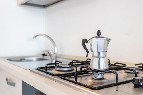 a tea kettle sitting on top of a stove at Appartamenti Rocca 'Ja in Castelsardo