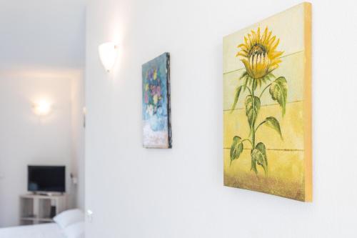 two paintings of a sunflower hanging on a wall at Appartamenti Rocca 'Ja in Castelsardo