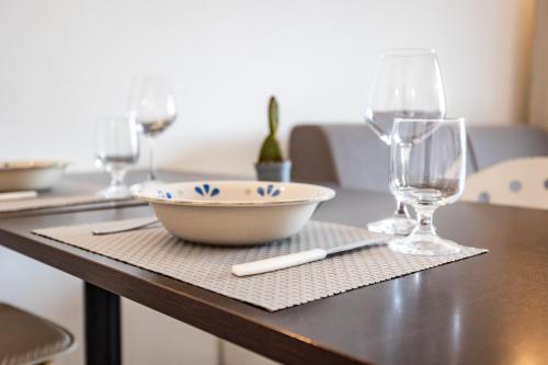a table with a bowl and wine glasses on it at Appartamenti Rocca 'Ja in Castelsardo