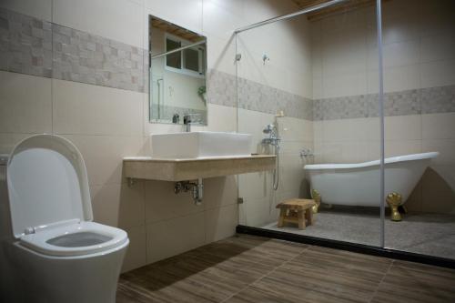 a bathroom with a toilet and a sink and a tub at Water Reflections at Ease in Donggang