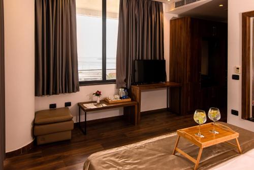 a living room with a bed and two glasses of wine at Deluxe & Executive SPA by Rafaelo in Shëngjin
