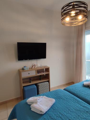 a bedroom with two beds and a desk with a television at KSP Studios in Perea
