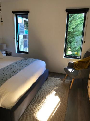 a bedroom with a bed and two windows at The Stewart in Margaret River Town