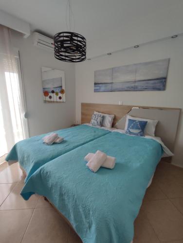 a bedroom with a large blue bed with towels on it at KSP Studios in Perea