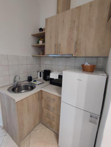 a small kitchen with a sink and a refrigerator at KSP Studios in Perea