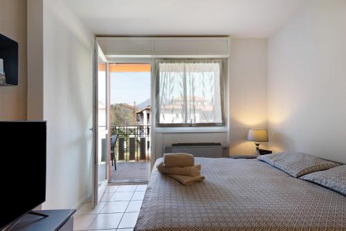 a bedroom with a large bed and a window at Maison del Sasso Lago Maggiore in Leggiuno