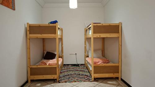 two bunk beds in a room with a wall at Afgo Hostel in Ouarzazate