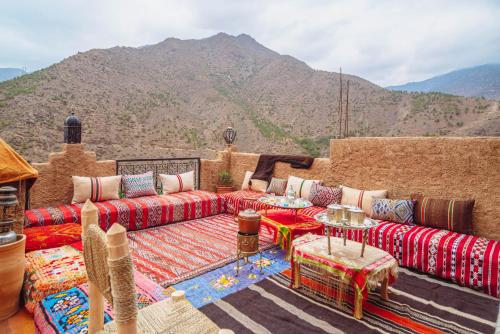 een woonkamer met banken en uitzicht op een berg bij Atlas Kasbah Lodge in Imlil
