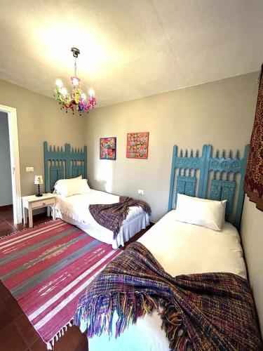 a bedroom with two beds and a chandelier at ATICO ELOY DELGADO in San Miguel de Abona