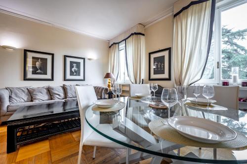YID D'Azeglio luxury apartment في فلورنسا: غرفة طعام مع طاولة زجاجية وأريكة