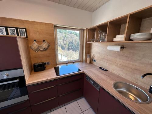 eine große Küche mit einem Waschbecken und einem Fenster in der Unterkunft Haus Kierberg in Monschau