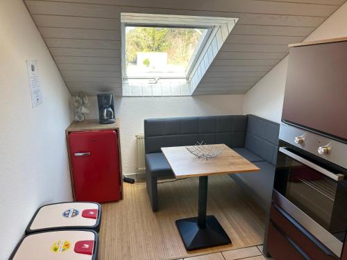 eine kleine Küche mit einem Tisch und einem Fenster in der Unterkunft Haus Kierberg in Monschau