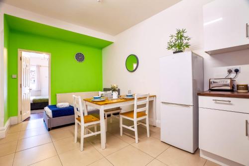una cucina con tavolo e parete verde di 090 Luxury 1 bedroom flat near Luton Town and station a Luton