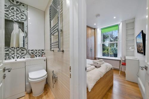 uma casa de banho com uma cama, um lavatório e um WC. em Finest Retreats - Hill Rise em Richmond