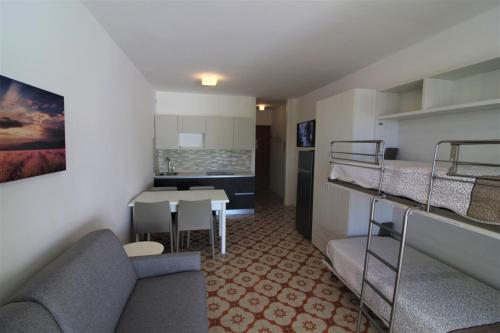 pequeña sala de estar con sofá y cocina en Residence Isvico, en Lignano Sabbiadoro