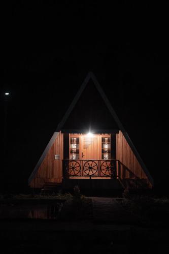 a cabin with a light in the window at night at Nsaho resort in Fort Portal