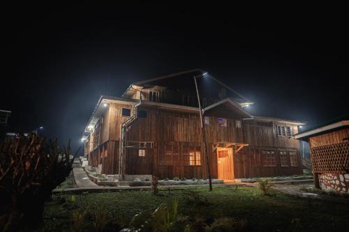 a wooden house at night with lights on it at Nsaho resort in Fort Portal