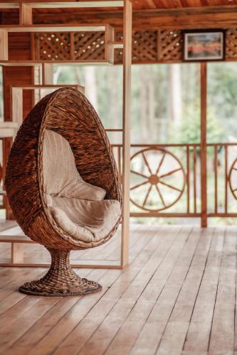 a wicker chair sitting on top of a wooden floor at Nsaho resort in Fort Portal
