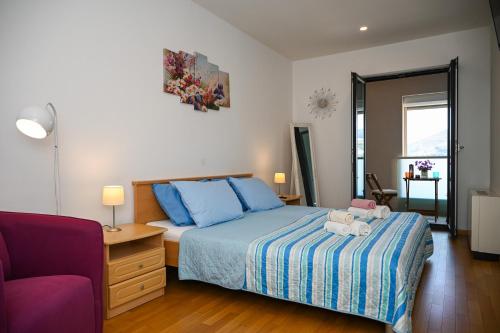 1 dormitorio con cama con sábanas azules y silla morada en Sea View Porto, en Dubrovnik