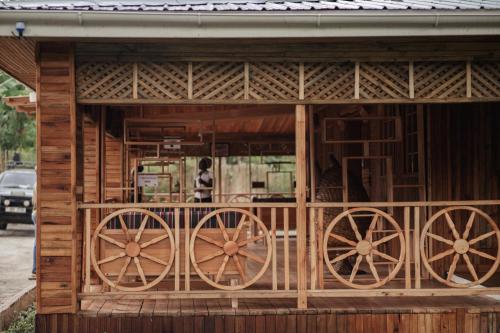 a wooden building with wooden wagon wheels on it at Nsaho resort in Fort Portal